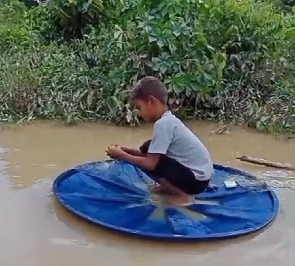 Em Cruzeiro do Sul, menino de 10 anos usa tampa de caixa d’água como canoa para ajudar no sustento da família