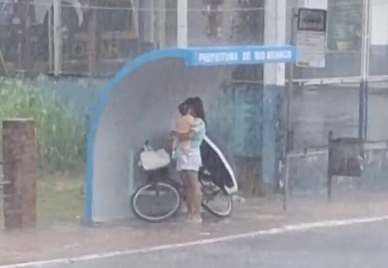 Mãe usa parada de ônibus para proteger bebê da chuva em Rio Branco