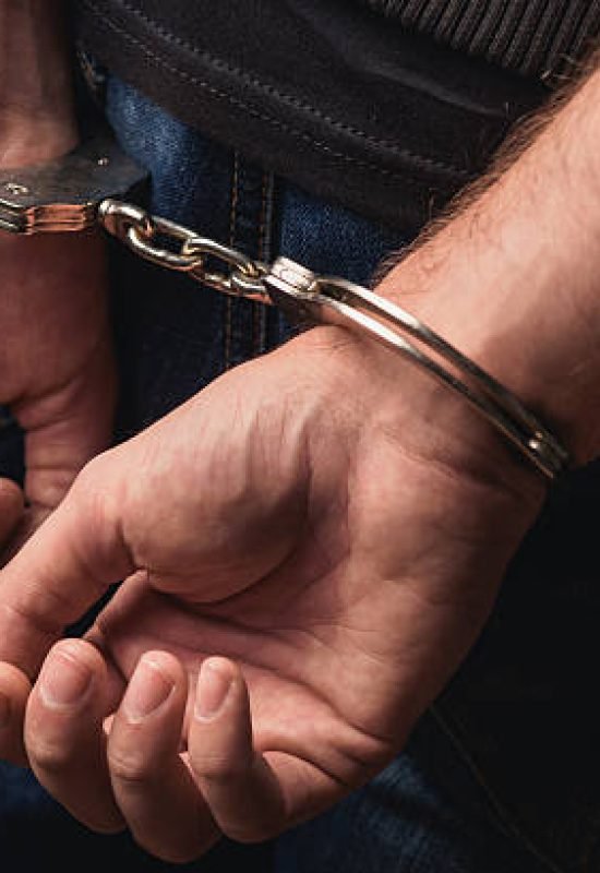 Close up of male hands in bracelets behind back
